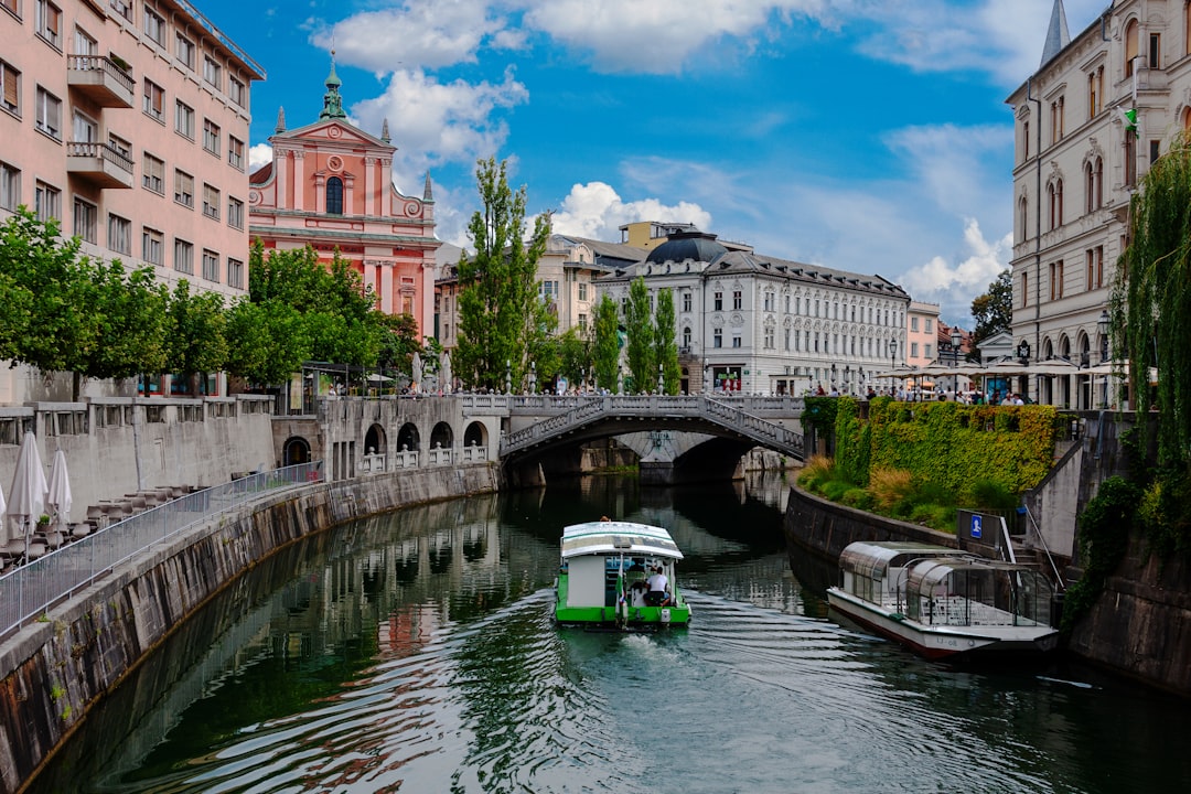 Ljubljana – zelena ladja na reki ob mostu podnevi